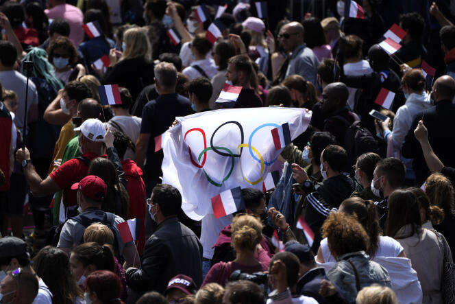 Des fans brandissent un drapeau olympique dans les jardins du Trocadéro, à Paris, le 21 août 2021.