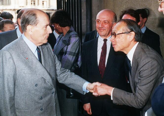 Le président François Mitterrand serre la main de l’architexte Ieoh Ming Pei, sous le regard du directeur du musée du Louvre, Michel Laclotte, lors de l’inauguration de la pyramide du Louvre, le 29 mars 1989 à Paris.