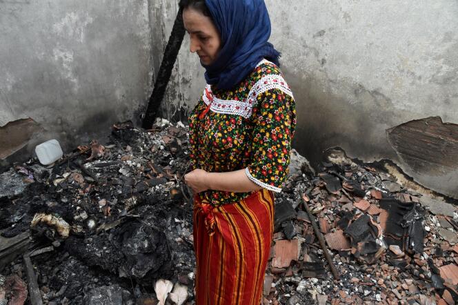 Une femme debout dans les décombres de sa maison brûlée dans la région d’Ait Daoud, au nord de l’Algérie, le 13 août 2021.