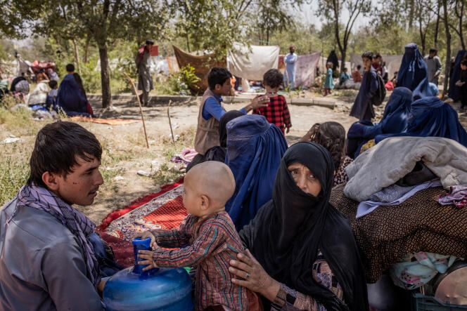 Jamshid Alizada (à gauche), avec des membres de sa famille, dans un camp de fortune abritant des réfugiés à Sarai Shamali, à Kaboul, en Afghanistan, le 10 août 2021.