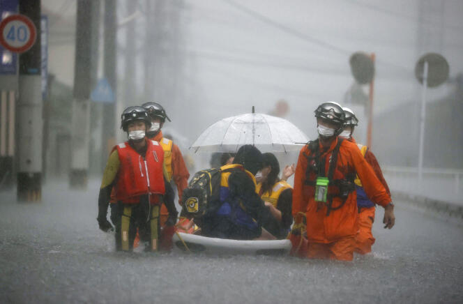 Des pompiers évacuent des habitants de Kurume (préfecture de Fukuoka), samedi 14 août 2021.