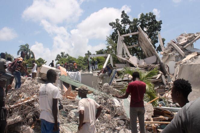 Des habitants fouillent dans les décombres d’un hôtel, samedi 14 août aux Cayes, pour tenter de trouver d’éventuels survivants.