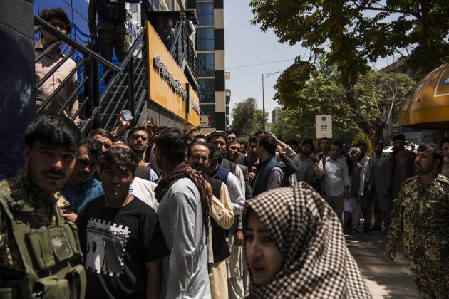 Des Afghans font la queue devant une banque du centre de Kaboul, alors que les talibans encerclent la ville, le 15 août 2021.