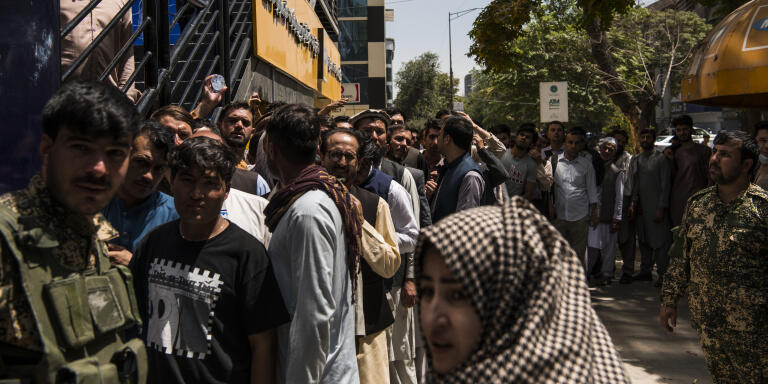 Account holders queue outside a bank in central Kabul as the Taliban, who had surrounded the city after overtaking huge swathes of the country in recent months, since the U.S. and international militaries began their final withdrawal on May 1, threatened to take the city by force. Ultimately, an agreement was reached by the Taliban leadership and the President Ashraf Ghani's Afghan Government, which saw President Ghani step down and flee the country in a transfer of power that was less bloodless than most expected, with barely any blood shed in the takeover of the capital. The Taliban leadership instructed their fighters not to enter the city and for government security forces to maintain security in the capital until further arrangements were made. By the afternoon most members of the government's security forces had shed their uniforms and most had left their posts, leaving somewhat of a power vacuum.