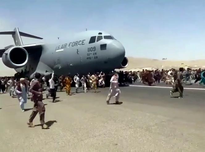 Des centaines de personnes tentent d’escalader un avion de l’US Air Force quittant Kaboul, le 16 août 2021.