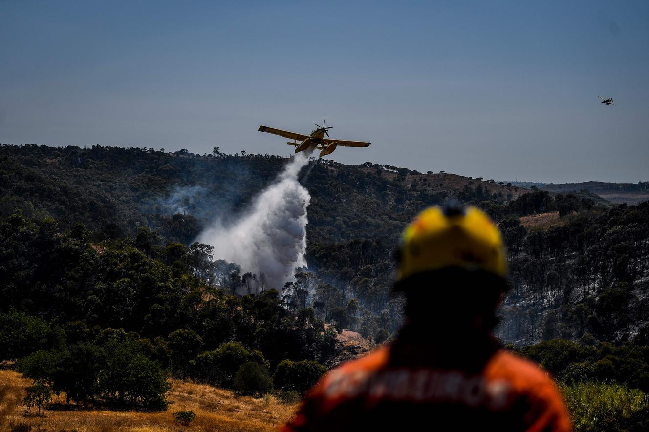Equipes de resgate tentam apagar um incêndio perto de Tavira, no sul de Portugal, no dia 17 de agosto.