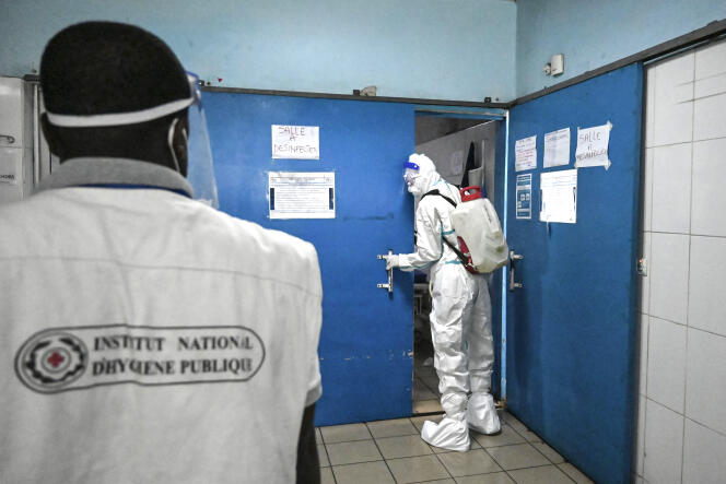 Un agent de l’Institut national d’hygiène publique (INHP) désinfecte les locaux du CHU de Cocody après le passage d’une patiente atteinte du virus Ebola, le 16 août 2021.