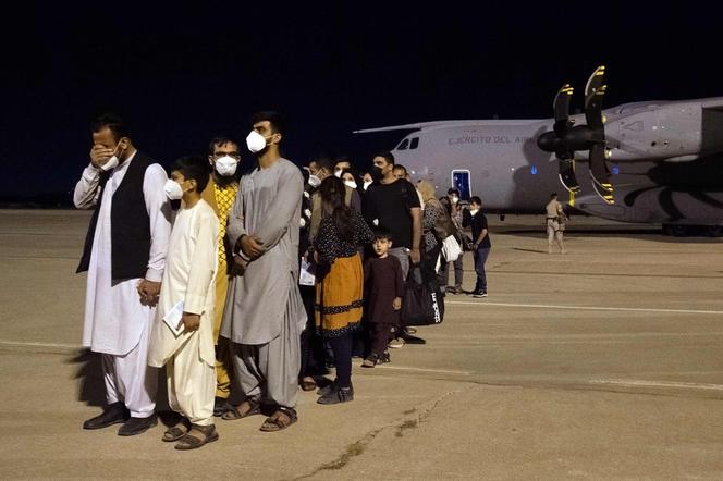 Un groupe de ressortissants afghans arrivés de Kaboul dans un Airbus de l’armée de l’air espagnole patientent sur la base aérienne de Torrejon de Ardoz, près de Madrid, le 19 août. Belen Diaz/AFP