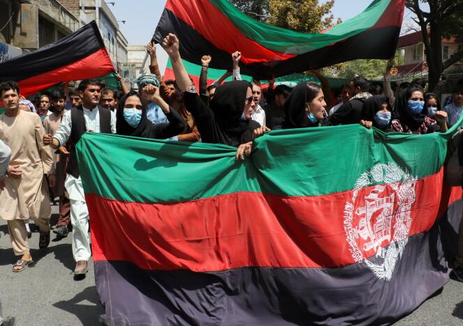 Des afghans tiennent le drapeau national lors d’une manifestation organisée à l’occasion de la fête de l’indépendance afghane à Kaboul, en Afghanistan, le 19 août 2021.
