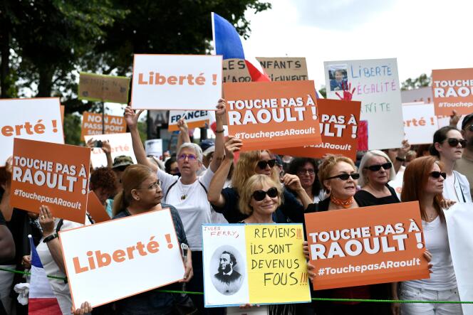 Des manifestants tiennent des pancartes en faveur du maintien de Didier Raoult à l’IHU, à Paris, le 21 août 2021.