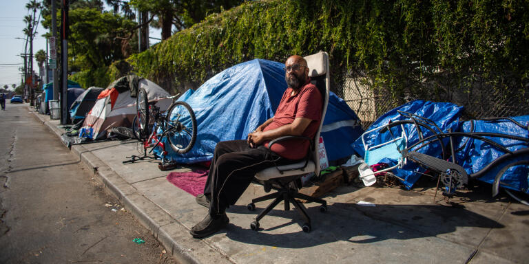 Albert Martinez, who has lived for 20 years on the streets of Los Angeles, sits outside his tent on a sidewalk in Venice Beach,California on August 12, 2021. (Photo by Apu GOMES / AFP)