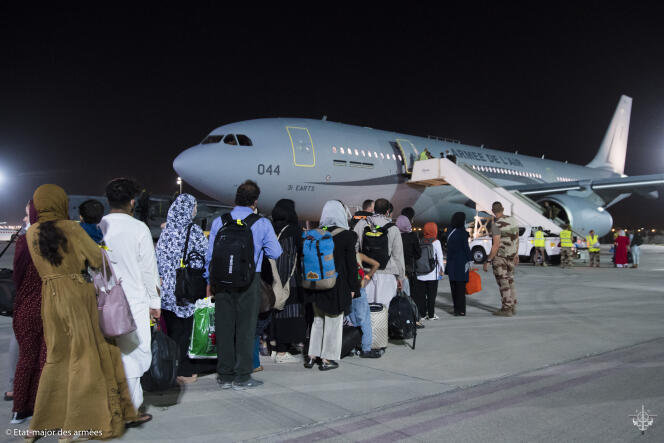 Des personnes évacuées d’Afghanistan par la France prennent l’avion vers Paris, le 26 août 2021, sur la base d’Al Dhafra, près d’Abou Dhabi.