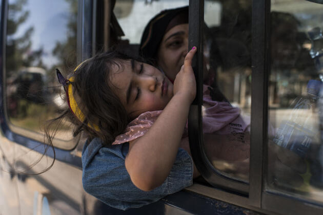 Une jeune fille s’endort dans un convoi de minibus bondés à destination de l’aéroport, le 24 août 2021.