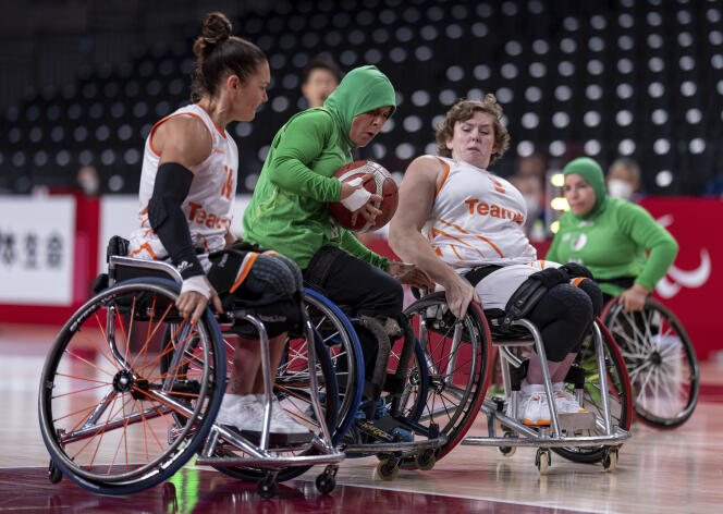L’Algérienne Djamila Khemgani entre deux joueurs néerlandais lors d’un match de basket-ball en fauteuil roulant aux Jeux paralympiques de Tokyo, le 27 août 2021.