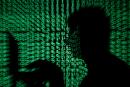 FILE PHOTO: A man holds a laptop computer as cyber code is projected on him in this illustration picture taken on May 13, 2017. REUTERS/Kacper Pempel//File Photo