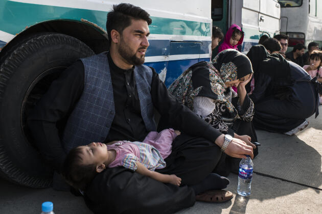 Un mari, sa femme et leur petite fille attendent à côté d’un minibus du côté militaire de l’aéroport international Hamid Karzaï, d’où ils seront finalement évacués. La famille faisait partie d’un total de 109 personnes. Kaboul le 22 août 2021.
