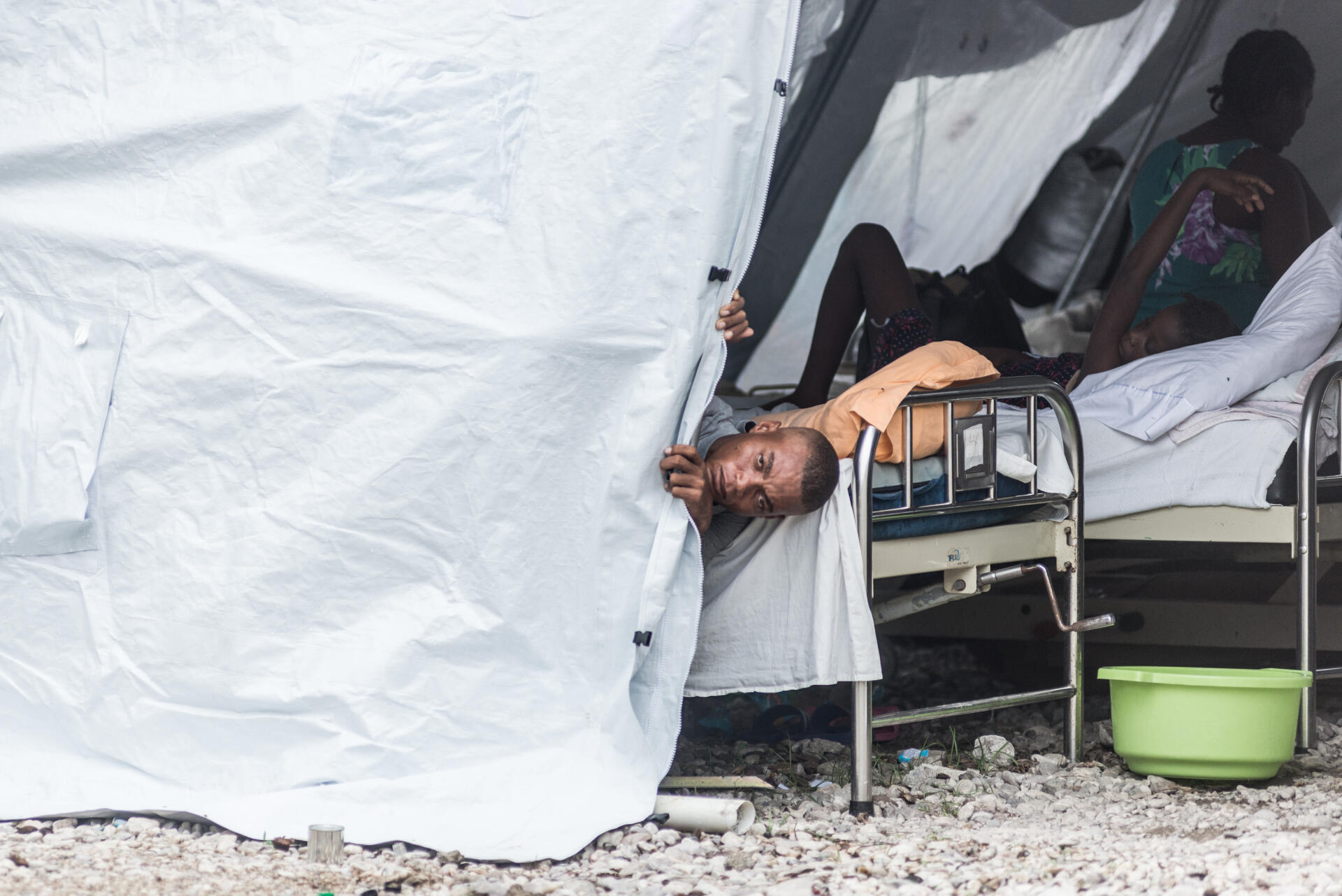 Un homme blessé lors du séisme, sous une tente dans la cour de l’hôpital de l’Immaculée-Conception des Cayes, chef-lieu du département du Sud en Haïti, le 26 août 2021.
