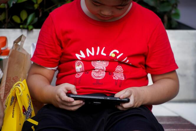 Un jeune Chinois jouant sur son téléphone, le 31 août 2021.