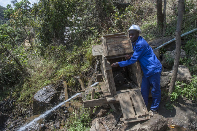 Colrerd Nkosi et sa turbine hydroélectrique artisanale qu’il a conçue près de son village de Yobe Nkosi, dans le nord du Malawi, le 23 août 2021.