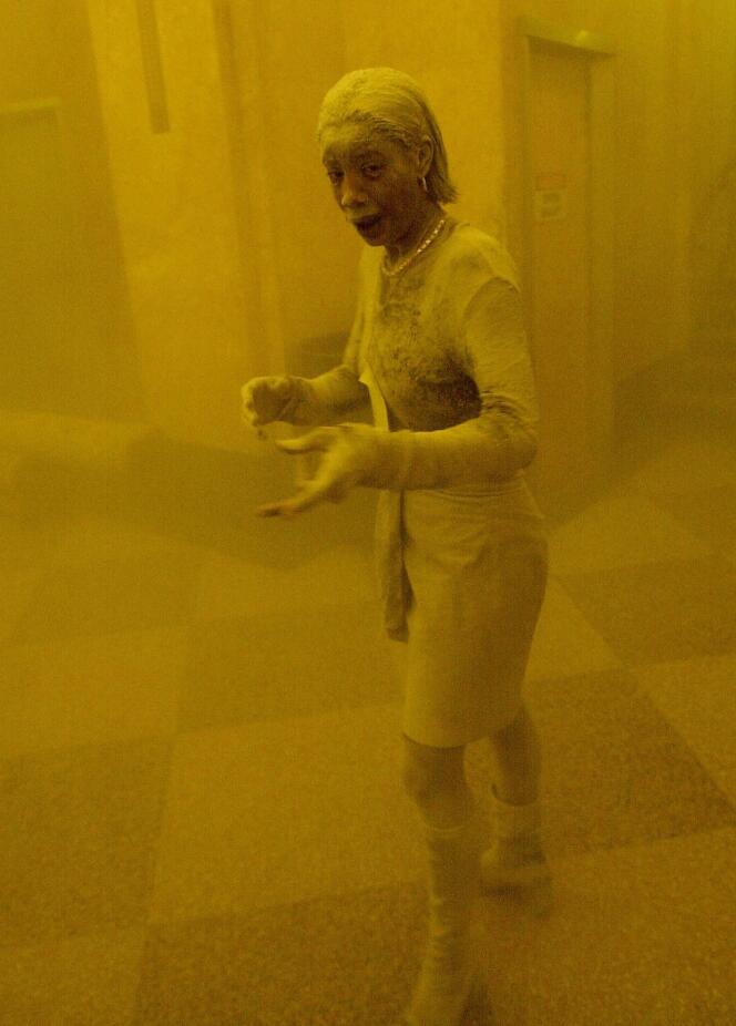 Une femme, Marcy Borders, couverte de poussière alors qu’elle se réfugie dans un immeuble de bureaux après l’effondrement de l’une des tours du World Trade Center à New York, le 11 septembre 2001. Un nuage de fumée et de poussière enveloppait la zone.