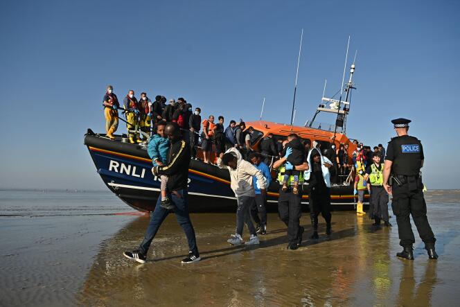 Des migrants débarquent à Dungeness, dans le sud de l’Angleterre, le 7 septembre 2021, après avoir été secourus par la Royal National Lifeboat Institution, insitution caritative de sauvetage des personnes en danger en mer dans les eaux des îles britanniques.