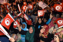 Tunisian Ennadha Party supporters wave flags as they wait for the party's leader to give a speech on October 27, 2014 in Tunis following the legislative election. The leader of Tunisia's Islamist Ennahda party congratulated his secular rival on October 26 for "his party's win" in a general election seen as critical for democracy in the cradle of the Arab Spring. The first parliamentary election since Tunisia's 2011 revolution pitted Ennahda against secular opponent Nidaa Tounes, with an array of leftist and Islamist groups also taking part. AFP PHOTO / FADEL SENNA (Photo by FADEL SENNA / AFP)