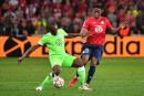 Wolfsburg's French defender Jerome Roussillon (L) is challenged by Lille's Canadian forward Jonathan David during the UEFA Champions League group G football match between Lille LOSC and Wolfsburg at the Pierre-Mauroy stadium in Villeneuve-d'Ascq, near Lille, northern France on September 14, 2021. (Photo by Denis Charlet / AFP) 
