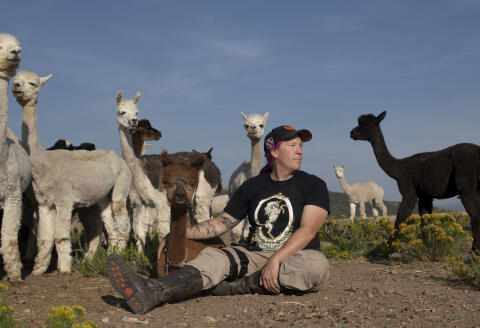 Penny Logue, founder of the Tenacious Unicorn Ranch, poses with her alpacas on Wednesday, Sept. 8, 2021 at the Tenacious Unicorn Ranch in Westcliffe, Colorado. The ranch is a haven for transgender and non-binary people, as well as a home for around 180 alpacas. Rachel Woolf for Le Monde