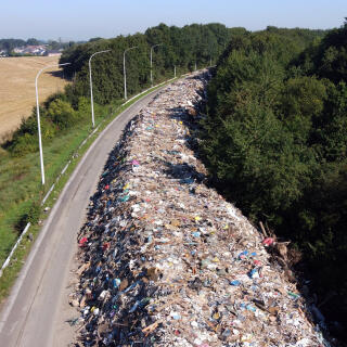 This aerial photograph taken on September 3, 2021 shows trash on the abandoned A601 highway at Juprelle, near Liege. - The makeshift dump - comprising 90,000 tonnes of domestic debris stretching a total eight kilometres (five miles) in both directions of the closed A601 motorway north of the city of Liege - is testament to the devastation wreaked by unprecedented floods in mid-June. (Photo by Kilian FICHOU / AFP)