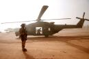 FILE PHOTO: FILE PHOTO: A French soldier stands guards in front of an NH90 Caiman military helicopter during Operation Barkhane in Ndaki, Mali, July 29, 2019. REUTERS/Benoit Tessier/File Photo