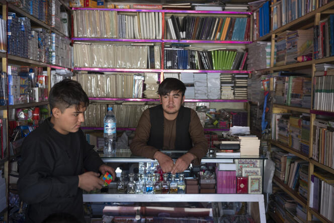 Amir (au centre), de l’ethnie hazara, dans sa librairie du quartier de Dasht-e-Barchi, dans l’ouest de Kaboul, le 16 septembre. A gauche, un client.
