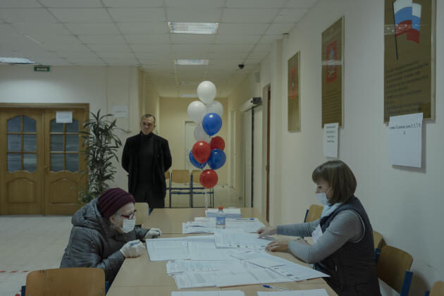 Une femme s’inscrit pour déposer son bulletin de vote, lors de l’élection de la Douma dans un bureau de Koroliov, en Russie, le 17 septembre 2021.