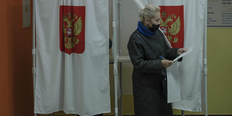 KOROLYOV, Russia - Septmeber 17, 2021. A woman leaves the voting booth after casting her ballot during the Duma election at a polling station in Korolyov, Russia, 17.09.2021. Emile Ducke pour Le Monde.