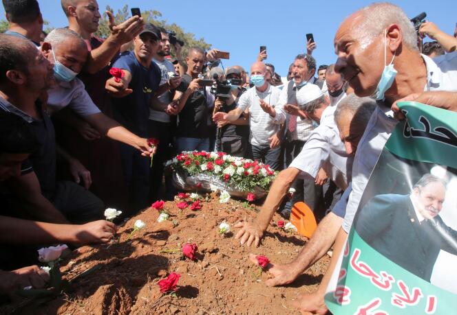 Des Algériens mettent des roses sur la tombe d’Abdelaziz Bouteflika au cimetière d’El Alia cemetery, à Alger, le 19 septembre 2021.