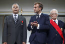 French President Emmanuel Macron, center, applauses after he honored with the legion of honor Salah Abdelkrim a former harki who was wounded, left, and general Francois Meyer who refused to execute order from above as he was a young soldier during a meeting in memory of the Algerians who fought alongside French colonial forces in Algeria's war, known as Harkis, at the Elysee Palace in Paris, Monday, Sept. 20, 2021. Macron's speech is the latest step in his efforts to reconcile France with its dark colonial past, especially in Algeria. (Gonzalo Fuentes/Pool Photo via AP)