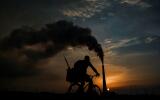 TOPSHOT - A man ridies his bicycle near the Ernesto Guevara thermoelectric plant in Santa Cruz del Norte, Mayabeque province, Cuba on September 20, 2021. (Photo by YAMIL LAGE / AFP)