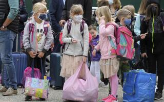 (FILES) In this file photograph taken on September 1, 2020, pupils, wearing masks, wait before entering the European school of Strasbourg, eastern France, at the start of the new school year amidst the Covid-19 epidemic. The obligation to wear a mask in elementary school will be lifted from October 4, 2021 in departments where the incidence rate of Covid will be less than 50 per 100,000 inhabitants, the government spokesman said on September 22, 2021. (Photo by FREDERICK FLORIN / AFP)