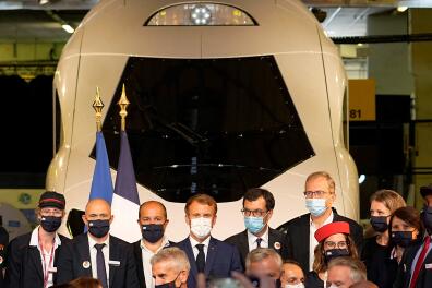 French President Emmanuel Macron (C) poses next to SNCF executives in front of a life-size replica of the next TGV high-speed train at the Gare de Lyon railway station, on September 17, 2021 in Paris, during a ceremony marking the 40th anniversary of French TGV high speed train. - On 22 September 1981, the first Train à Grand Vitesse line from Paris to Lyon opened to the public. (Photo by Michel Euler / POOL / AFP)