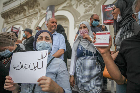 A woman holds a placard that reads in Arabic ‘no to the coup’, during a demonstration held in Tunis, Tunisia, on September 11, 2021, to call for the release of the independent Tunisian MP Yassine Ayari, who was arrested and sentenced to two months in jail by the military court for a 2018 verdict against him in the Military Court of Appeal for “participating in an act aimed at destroying the morale of the army” after he published Facebook posts that were critical of the military. (Photo by Chedly Ben Ibrahim/NurPhoto) (Photo by Chedly Ben Ibrahim / NurPhoto / NurPhoto via AFP)