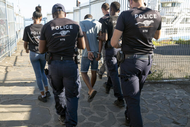 Des membres du Groupe d’appui opérationnel de la police aux frontières escortent un homme n’ayant pas de papiers, à Mayotte, le 26 mars 2021.