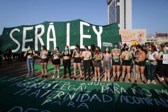 Des manifestants brandissent un drapeau vert, symbole de la lutte pour la dépénalisation de l’avortement, à Santiago du Chili, le 28 septembre 2021.