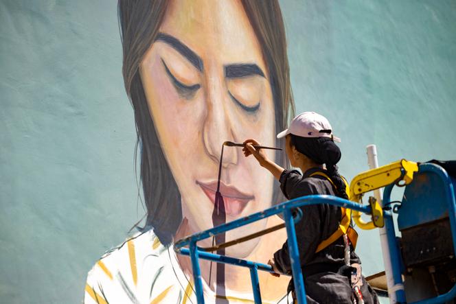 L’artiste marocaine Imane Droby travaille sur une fresque murale pendant le festival de street art Jidar dans la capitale Rabat, le 20 septembre 2021.