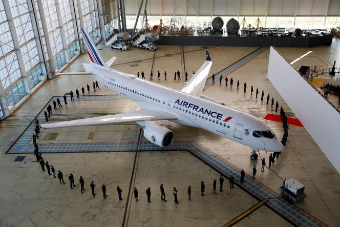 Des salariés d’Air France autour d’un Airbus A220 dans un hangar de l’aéroport de Roissy-Charles-de-Gaulle, à Roissy (Val-d’Oise), le 29 septembre 2021.