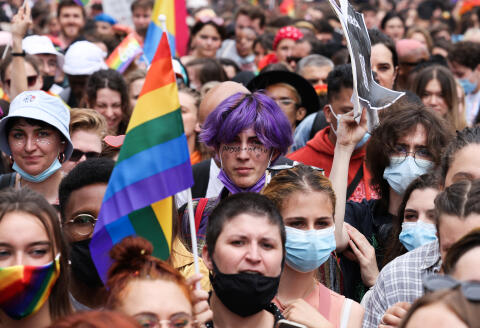 A participant holds a rainbow flag as people take part at the annual Pride March parade in Paris on June 26, 2021.