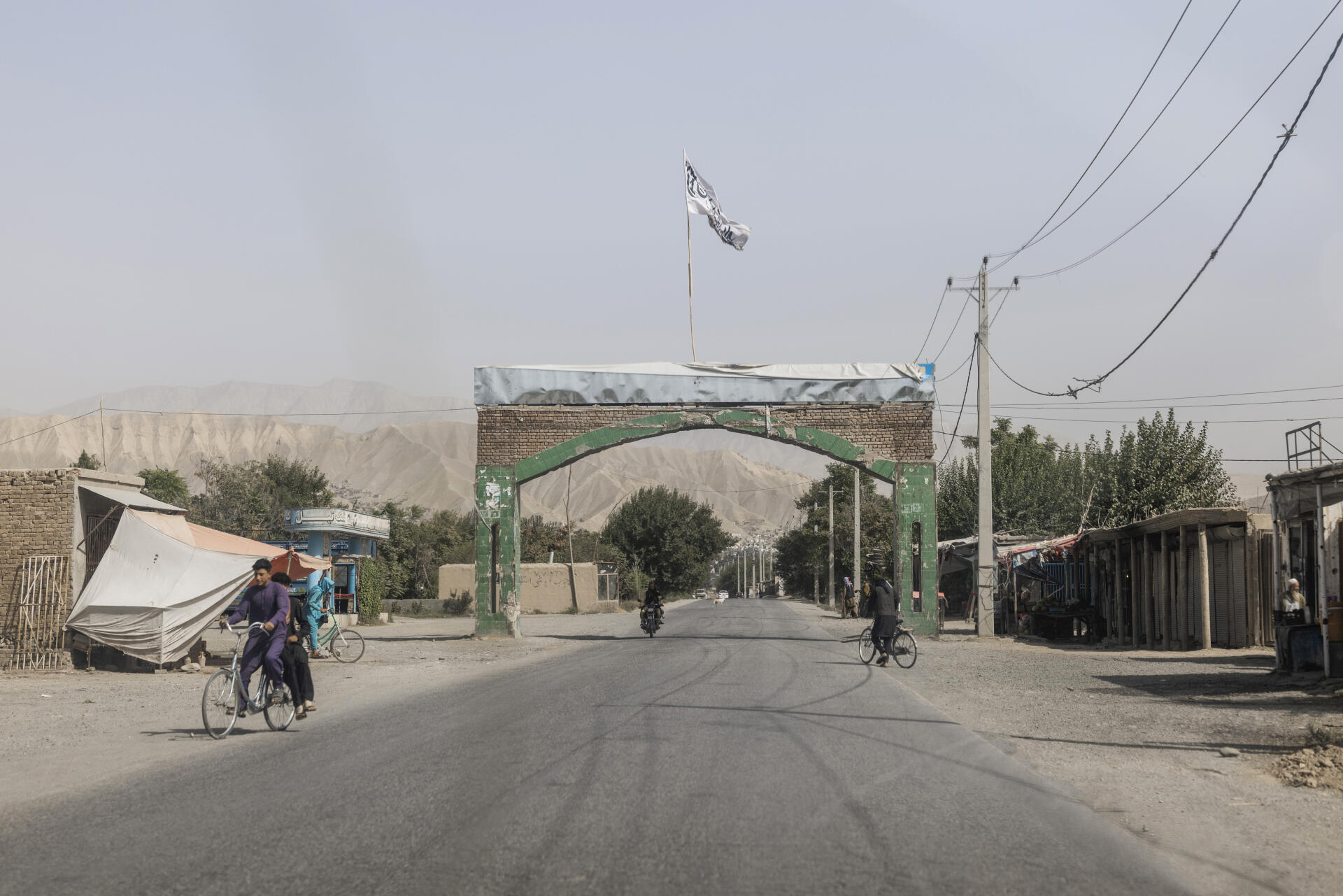 Un drapeau taliban surplombe l’entrée de la ville de Pol-e Khomri, dans la province de Baghlan, le 12 septembre 2021. L’armée afghane a combattu pendant deux mois les talibans avant de leur abandonner la ville, faute de munitions.