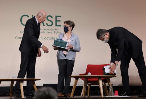 Commission president Jean-Marc Sauve (L), hands copies of the report to Catholic Bishop Eric de Moulins-Beaufort (R), president of the Bishops' Conference of France (CEF), and Sister Veronique Margron (C), president of the Religious' Conference of France (CORREF), during the publishing of a report by an independant commission into sexual abuse by church officials (Ciase) on October 5, 2021, in Paris. An independent inquiry into alleged sex abuse of minors by French Catholic priests, deacons and other clergy has found some 216,000 victims of paedophilia from 1950 to 2020, a "massive phenomenon" that was covered up for decades by a "veil of silence." (Photo by Thomas COEX / POOL / AFP)