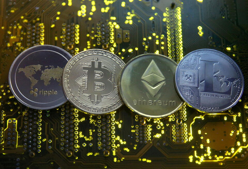 FILE PHOTO: Representations of the Ripple, bitcoin, etherum and Litecoin virtual currencies are seen on a PC motherboard in this illustration picture, February 14, 2018. REUTERS/Dado Ruvic//File Photo