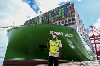 A port worker stands next to the Ever Ace container ship, one of the world's largest container ships, after it docked at the Colombo International Container Terminal (CICT) port in Colombo on October 6, 2021. (Photo by ISHARA S. KODIKARA / AFP)