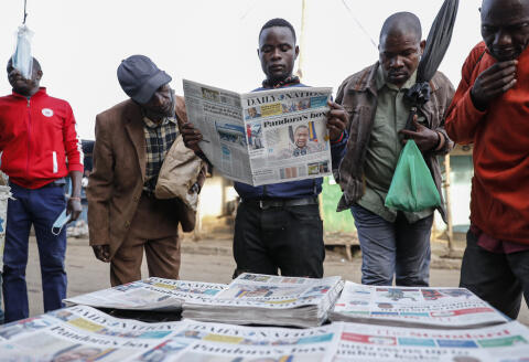 Locals read the morning newspapers reporting a statement issued by President Uhuru Kenyatta following reports that he is among more than 330 current and former politicians identified as beneficiaries of secret financial accounts, in the low-income Kibera neighborhood of Nairobi, Kenya Tuesday, Oct. 5, 2021. Calls are growing for an end to the financial secrecy and shell companies that have allowed many of the world's richest and most powerful people to hide their wealth from tax collectors. (AP Photo/Brian Inganga)