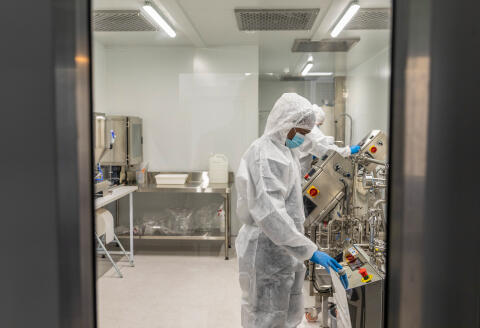 Technicians wearing protective suits operate machinery inside the Afrigen Biologics &amp; Vaccines Ltd. laboratory facility in Cape Town, South Africa, on Monday, July 12, 2021. The World Health Organization announced it will establish its first-ever mRNA technology transfer hub in Cape Town in an agreement with Afrigen and the Biovac Institute. Photographer: Dwayne Senior/Bloomberg via Getty Images